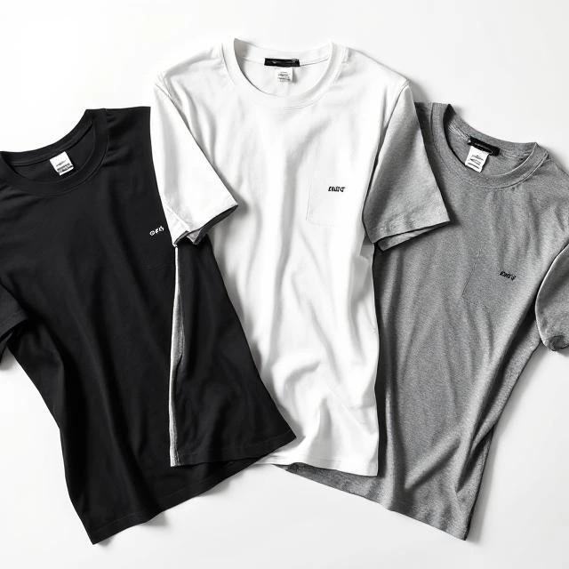 Flat lay of pastel cotton T-shirts with embroidered chest logo and woven patch near hem - premium custom T-shirt manufacturer in Tiruppur India.