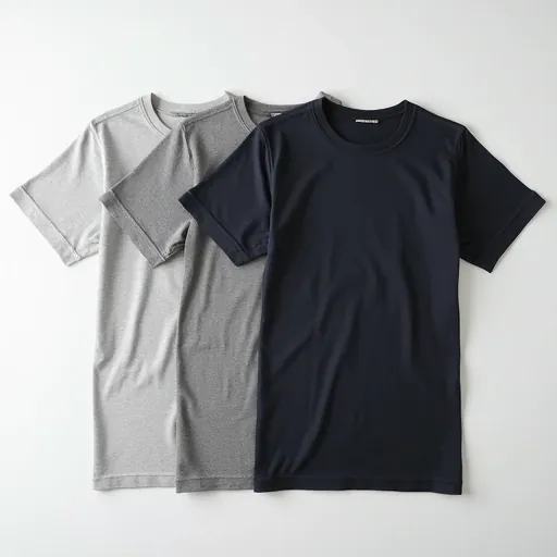 Close-up flat lay of white and charcoal plain cotton T-shirts showing fine knit texture and ribbed neckband — premium cotton manufacturer Tiruppur.